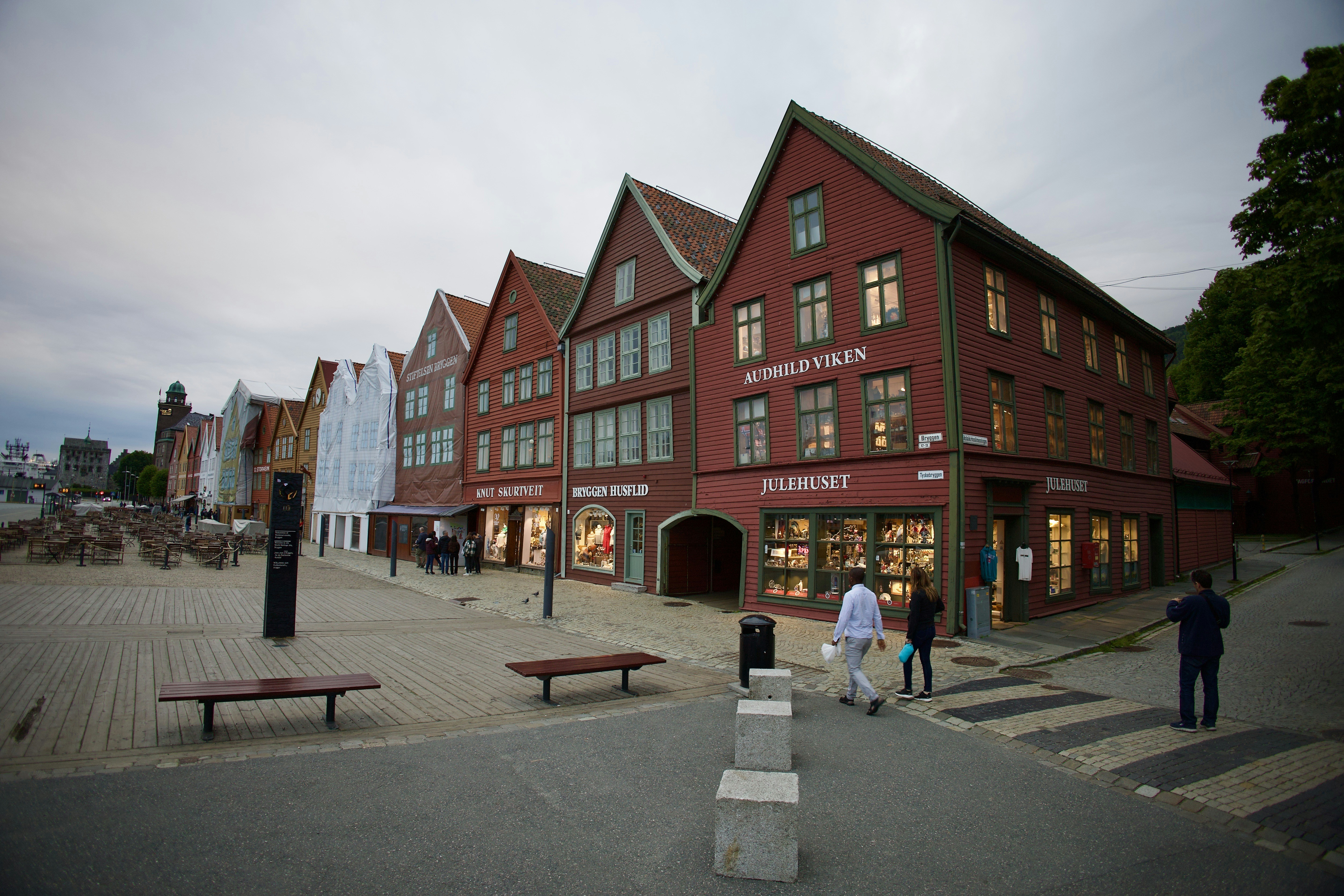 a group of people walking past a red building